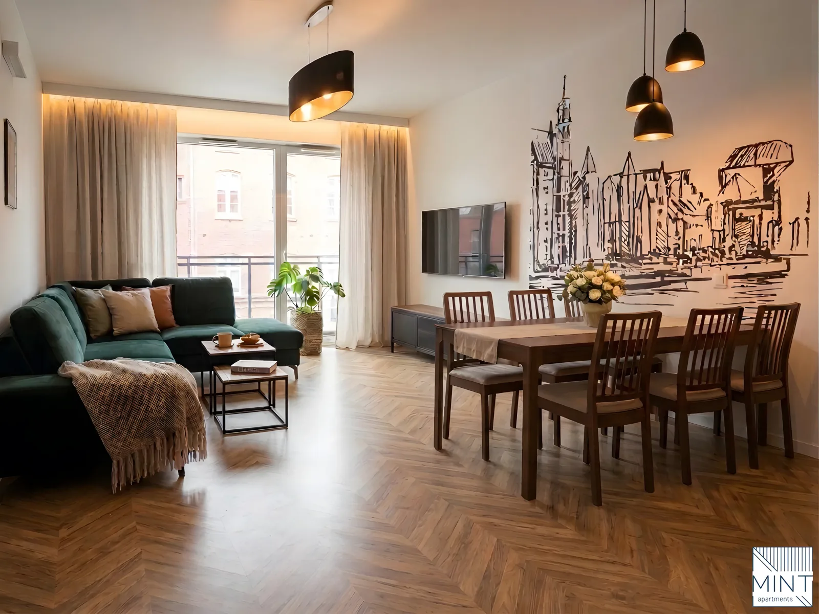 Apartament Bastion Wałowa — przestronny salon z dużym stołem jadalnianym