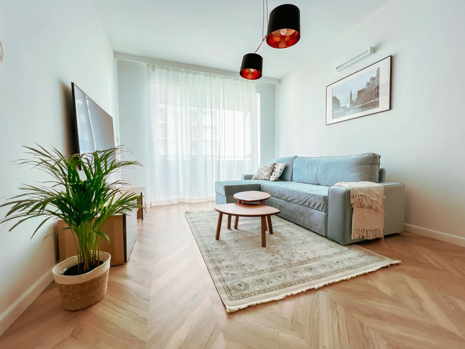 Apartament Deluxe Bastion Wałowa — jasny salon z kanapą i oknem na Wałową