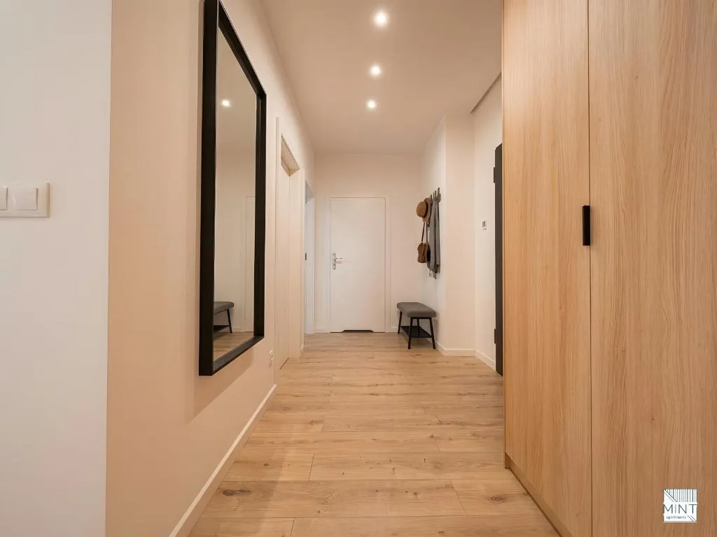 Apartament z patio na Dokach — salon z kanapą i fotelem