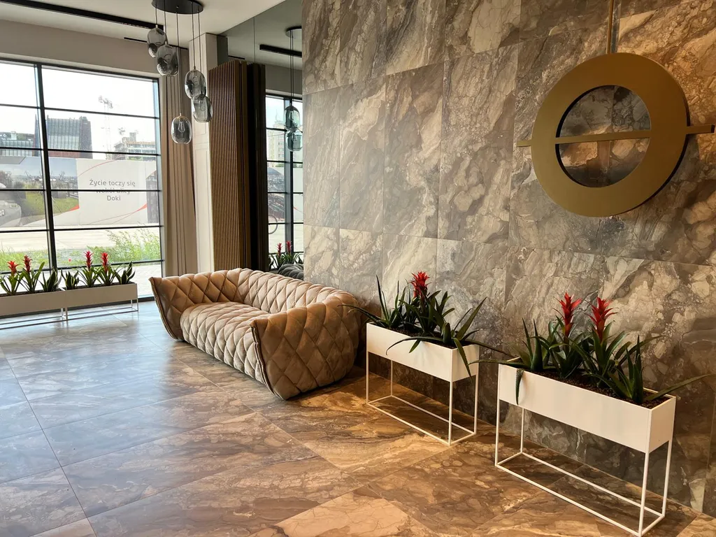 Przestronny salon apartamentu Mint w DOKI z sofą — dobre miejsce zbiórki przed wieczorem kawalerskim