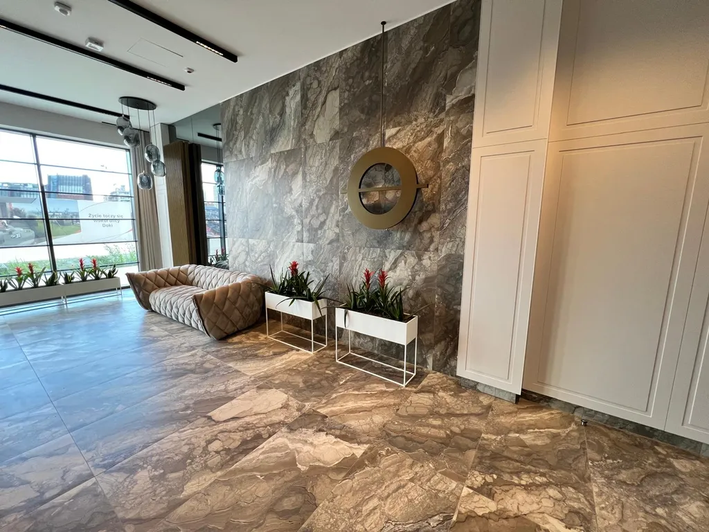 Lobby Mint Apartments w DOKI — szerszy widok na przestronny hol wejściowy z designem industrialnym
